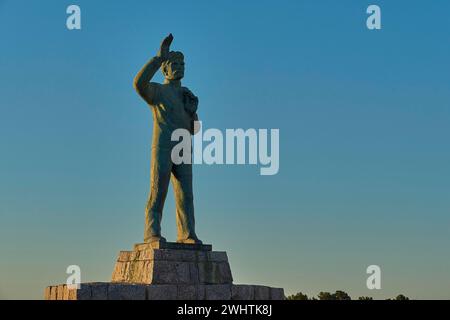 Statue d'un homme avec le bras tendu vers le ciel à l'aube, statue en bronze d'un marin agitant à la mémoire des âmes perdues en mer, Gythio, Mani Banque D'Images