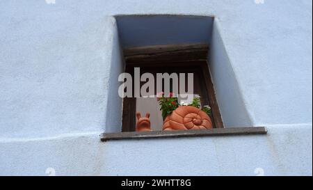Posada, Italie, 1er août 2021. Un escargot en terre cuite sur un rebord de fenêtre pendant une journée d'été. Banque D'Images
