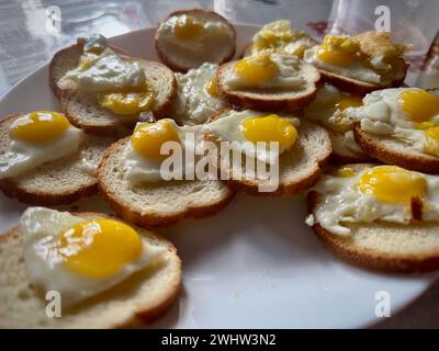 Mini œufs Sunny-Side-Up faits maison sur pain grillé : une délicieuse présentation du petit déjeuner Banque D'Images