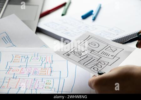 Développement et croquis sur papier d'une application mobile individuelle pour le bureau et les mains du designer, graphisme, travail de designer Banque D'Images