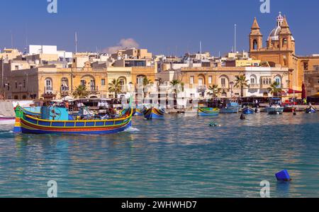 Bateaux de pêche traditionnels colorés en bois luzzi dans le village Marsaxlokk par une journée ensoleillée. Malte. Banque D'Images