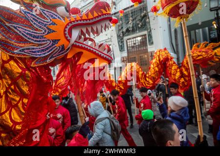 Moscou, Russie. 10 février 2024. Les artistes jouent une danse dragon pendant la célébration du nouvel an lunaire chinois dans une rue dans le cadre du Festival du nouvel an chinois à Moscou à Kamergersky Lane, en Russie Banque D'Images