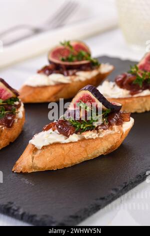 Crostini avec confiture d'oignons, figues et fromage Banque D'Images