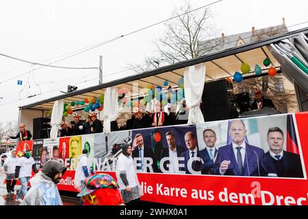 Erfurt, Allemagne. 11 février 2024. Fixation traditionnelle du carnaval allemand 2024 à Erfurt, Thuringe. Les gens sur la rue de la ville célébrant le festival, la danse, s'amuser à flotter à travers le centre-ville jetant des bonbons et des bonbons aux spectateurs publics. Temps de fortes pluies. Banque D'Images