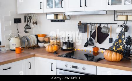 Décor de la cuisine classique blanche avec des citrouilles pour Halloween et la récolte. Ambiance d'automne dans l'intérieur de la maison, style loft moderne. Banque D'Images