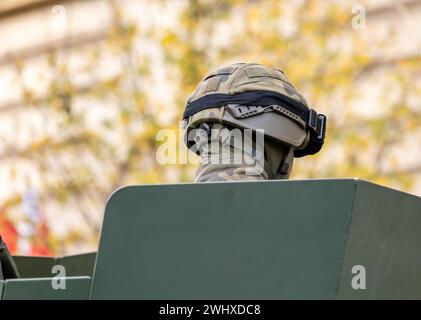 Soldat militaire anonyme dans un uniforme de camouflage camouflage et un casque assis dans un véhicule blindé tête de tourelle gros plan, détail de dos. Armée, bébé Banque D'Images