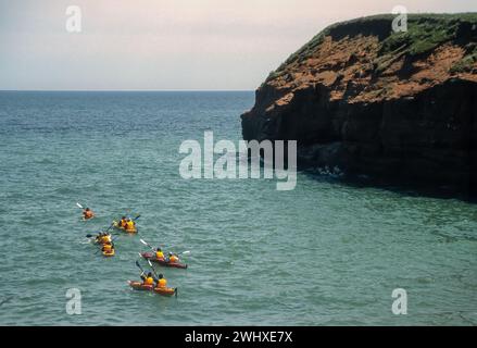 Kayak et exploration des falaises de grès rouge des Îles de Madelaine, Îles de la Madelaine, Québec, dans le golfe du Saint-Laurent. Banque D'Images