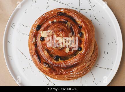 Pain sucré avec raisins secs et amandes sur une assiette blanche Banque D'Images