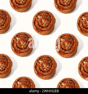 motif avec des petits pains à la cannelle sur fond blanc. Vue de dessus. Banque D'Images