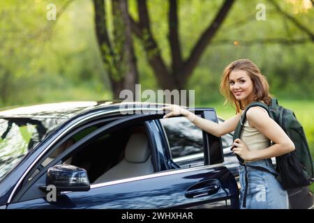 Femme heureuse conductrice à la voiture souriante. Mignonne jeune femme brune heureuse voiture de conduite. Banque D'Images