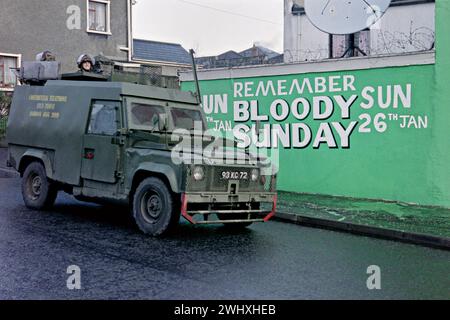 Des soldats britanniques patrouillent dans un Land Rover blindé devant une murale marquant le 20e anniversaire de Bloody Sunday dans la région de Bogside, le 24 janvier 1992 à Londonderry, Irlande du Nord, Royaume-Uni. Des groupes de défense des droits civils planifient une marche massive en mémoire des 14 marcheurs civils tués par des soldats britanniques en 1972. Banque D'Images