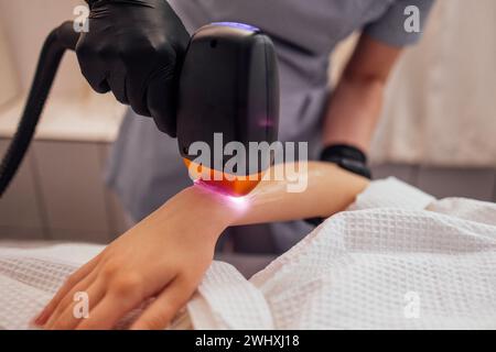 Jeune femme qui reçoit une épilation photo lors d'une visite au centre de beauté dans un salon de beauté Banque D'Images