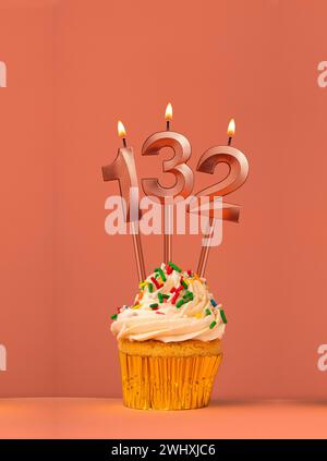 Cupcake d'anniversaire avec numéro de bougie 132 - fond fusion corail Banque D'Images