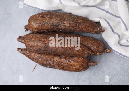 Racines de manioc fraîches sur table grise, vue de dessus Banque D'Images