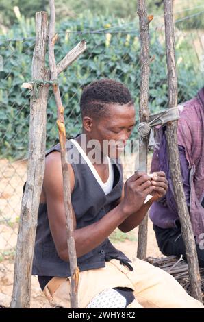 jeune homme africain avec un personnage dur roulant un joint de marijuana, ghetto township afrique du sud, colonie informelle Banque D'Images