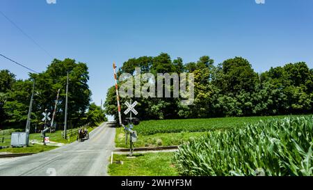 Vue d'un Amish Open Horse and Carriage voyageant sur une route rurale Banque D'Images