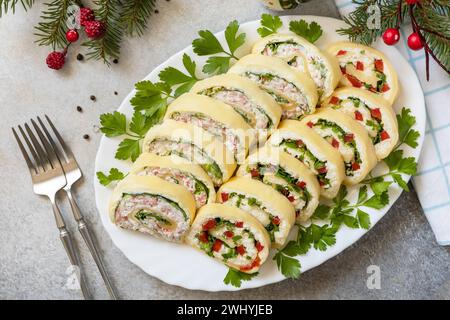 Hors-d'œuvre créatifs noël. Rouleaux de fromage avec bâtonnets de crabe, fromage à la crème, œufs et fromage à la crème, poivron doux, légumes verts. Voir fr Banque D'Images