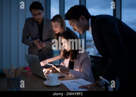 Groupe de courtiers négociants internationaux travaillant activement la nuit au bureau, Une jeune femme travaille Hustle pour présenter un cl Banque D'Images