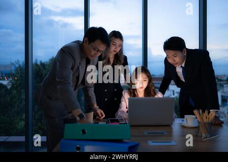 Groupe de courtiers négociants internationaux travaillant activement la nuit au bureau, Une jeune femme travaille Hustle pour présenter un cl Banque D'Images