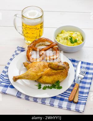 Poulet à moitié rôti, bière, bretzel et salade de pommes de terre Banque D'Images