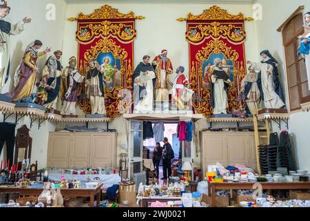 Statues de saints catholiques au-dessus d'une friperie à la Valette, Malte Banque D'Images