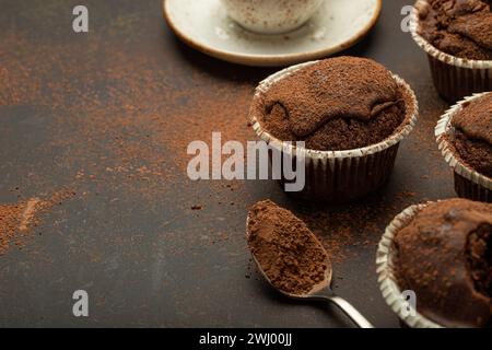 Muffins brunis au chocolat et au cacao avec cappuccino au café dans la vue d'angle de tasse sur fond de pierre rustique brun, dar doux fait maison Banque D'Images