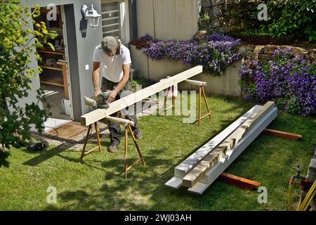 Préparation meulage des boiseries à l'extérieur. travailler avec une ponceuse orbitale aléatoire au printemps. Menuiserie Banque D'Images