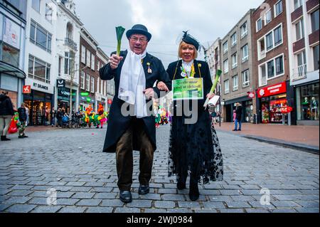 Nimègue, pays-Bas. 11 février 2024. Un couple est vu parader tout en portant des costumes traditionnels. À Nimègue, aux pays-Bas, le défilé du carnaval se compose d'un flotteur tiré par un véhicule électrique rempli des princes et princesses de l'année. Le reste de la parade se compose de gens habillés de costumes colorés et de groupes de musique. L'attraction principale chaque année est le costume que le maire de la ville Huber Bruls portera, cette année le thème était Flower Power. Crédit : SOPA images Limited/Alamy Live News Banque D'Images