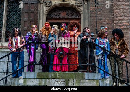 Nimègue, pays-Bas. 11 février 2024. Le maire de la ville Hubert Bruls (costume orange) est vu poser pour les photos pendant le carnaval. À Nimègue, aux pays-Bas, le défilé du carnaval se compose d'un flotteur tiré par un véhicule électrique rempli des princes et princesses de l'année. Le reste de la parade se compose de gens habillés de costumes colorés et de groupes de musique. L'attraction principale chaque année est le costume que le maire de la ville Huber Bruls portera, cette année le thème était Flower Power. Crédit : SOPA images Limited/Alamy Live News Banque D'Images