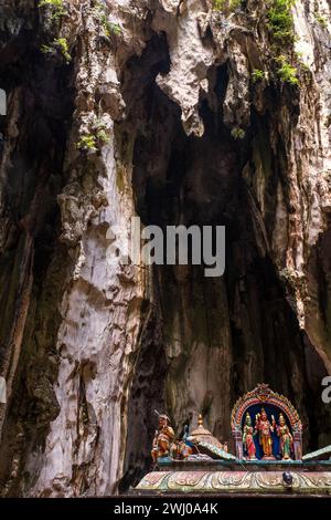 Figures exquises de divinités hindoues sur le toit d'un temple hindou avec des stalactites cavernes surplombant. Grottes de Batu, Malaisie Banque D'Images