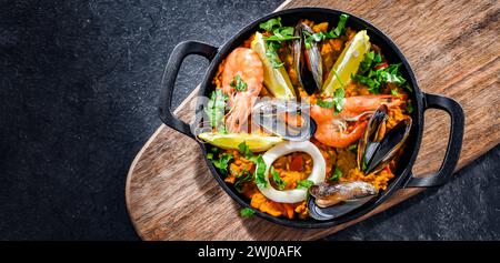 Paella de fruits de mer servie dans une poêle en fonte. Banque D'Images