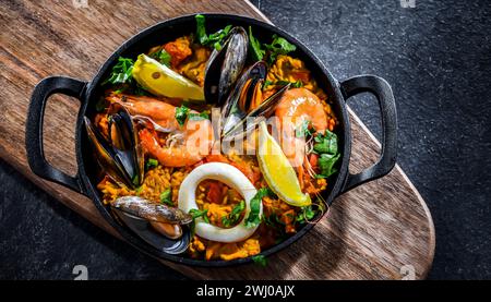 Paella de fruits de mer servie dans une poêle en fonte. Banque D'Images