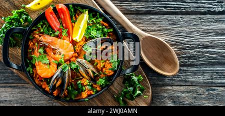 Paella de fruits de mer servie dans une poêle en fonte. Banque D'Images