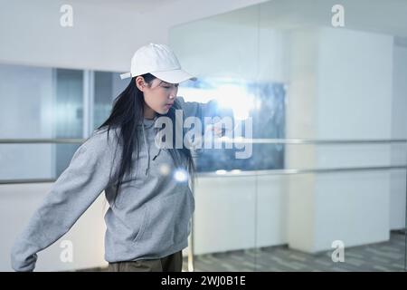 Jeune femme talentueuse pratiquant des mouvements hip hop vigoureux en studio de danse Banque D'Images