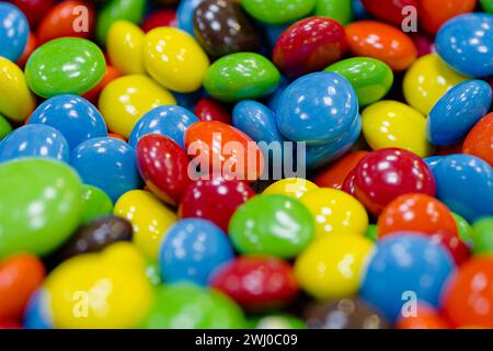 Dragées sucrées glacées multicolores assorties, avec des noix, des graines ou un centre de chocolat, fond de confiserie abstraite Banque D'Images