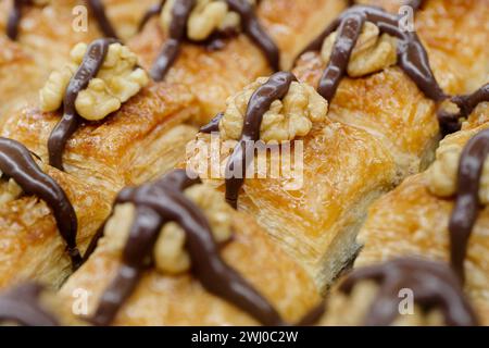 Dessert turc traditionnel, baklava, décoré avec des noix et du chocolat, fond de nourriture abstraite Banque D'Images