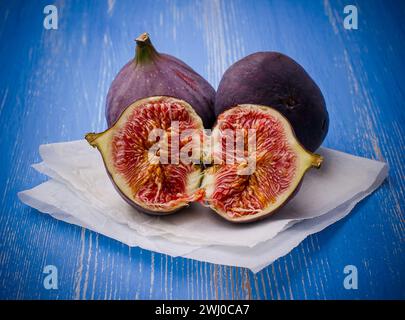 Trois figues mûres sur fond bleu Banque D'Images