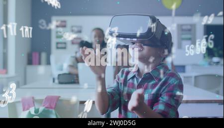 Image du traitement des données sur un écolier biracial heureux utilisant la classe de casque vr Banque D'Images