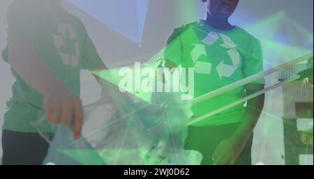 Image de réseaux sur des écoliers heureux divers dans le recyclage t-shirts de collecte des déchets Banque D'Images