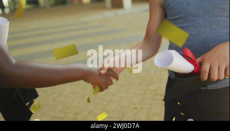 Image de confettis dorés sur des écoliers heureux divers avec diplôme et tableau de mortier serrant la main Banque D'Images