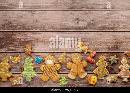 Les biscuits glacés colorés reposent le long du bord inférieur sur des planches verticales brunes Banque D'Images