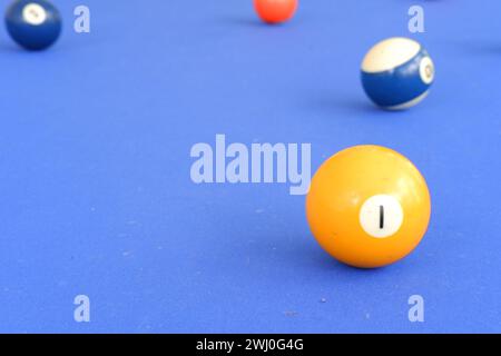 Boules de billard et queue de billard se rapprochent sur la table de billard bleu à l'extérieur dans une journée d'été ensoleillée. Boule avec le numéro 1 sur le devant Banque D'Images