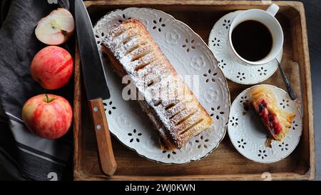 Strudel de pomme entier traditionnel fraîchement cuit sur une table en bois, gros plan. Pâtisseries fraîches faites maison avec garniture de fruits ou de baies Banque D'Images