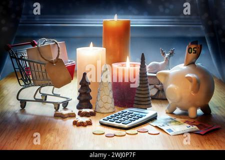 Shopping de vacances. Calculatrice, décoration de Noël, calculatrice, tirelire, panier et bougies sur une table contre un bleu Banque D'Images