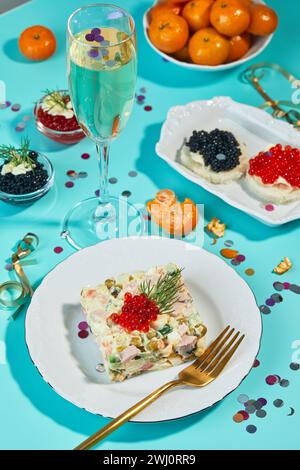 Table du nouvel an ou de Noël pour une fête à la russe avec champagne en verre, mandarines et salade Olivier en portions Banque D'Images