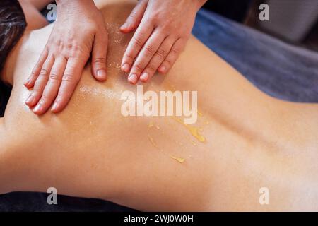 Massage de la zone du collier cervical avec du miel. Banque D'Images