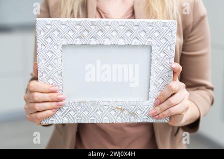 Cadre photo blanc à la main sur fond blanc. Isolation Banque D'Images