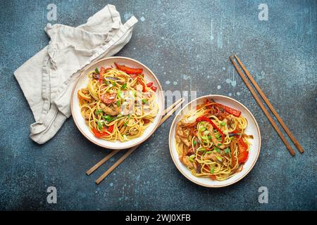 Deux bols avec Chow Mein ou Lo Mein, nouilles sautées chinoises traditionnelles avec viande et légumes, servies avec baguettes top v Banque D'Images