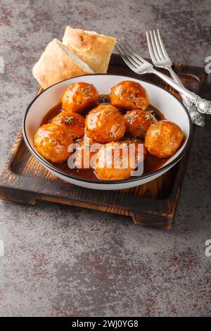 Boulettes de poulet dans le glaçage au miel et la sauce épicée gros plan dans un bol sur la table. Vertical Banque D'Images