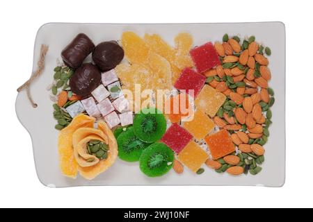 Desserts sucrés dans l'assiette pour les vacances. Marmelade, fruits confits, mangue, kiwi, noix, graines, bonbons au chocolat et délice turc dans une assiette. Top vie Banque D'Images